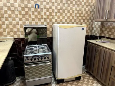 a person is standing in a kitchen with a stove at Garden Level Oasis Near Nile in Luxor