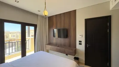 a bedroom with a bed and a tv on a wall at Galaxy Aldau Hieghts in Hurghada