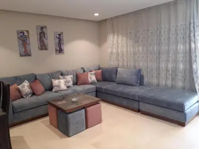 a living room with a blue couch and a table at Mangarove m3 1c 11 in Hurghada