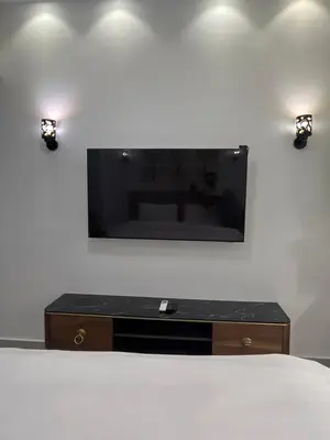 a bedroom with a tv on a wall with a bed at Benashti Hurghada apartment in Hurghada