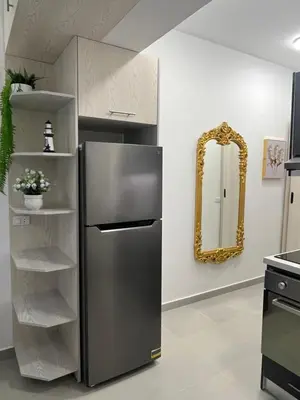 a stainless steel refrigerator in a kitchen with a mirror at Benashti Hurghada apartment in Hurghada