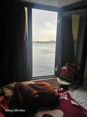 a bedroom with a window looking out at the water at The grand in Nag` el-Ramla