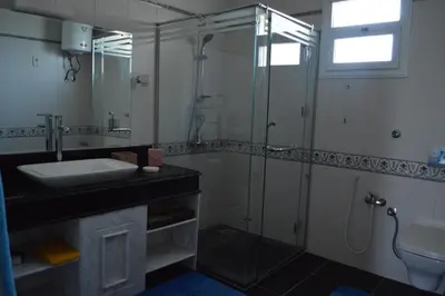 a bathroom with a glass shower and a sink at House of Hathor in Luxor