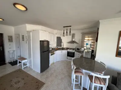 a kitchen with a refrigerator and a table and chairs at Regency Towers Apartments in Hurghada