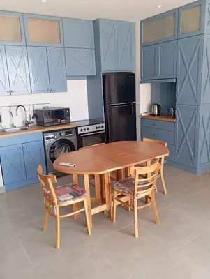 a kitchen with a wooden table and two chairs at Charment Chalet Somabay in Hurghada
