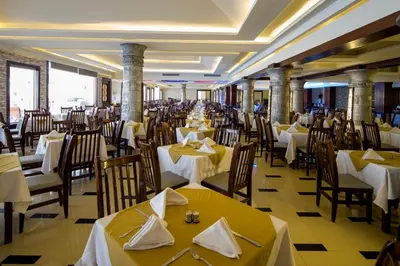 a restaurant with tables and chairs with yellow table cloth at Poolside Chalet Ground Floor Aqua Park - BY MAMO Property in Hurghada