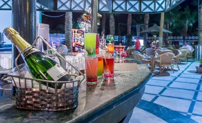 a table with glasses of wine and a basket of drinks at Poolside Chalet Ground Floor Aqua Park - BY MAMO Property in Hurghada