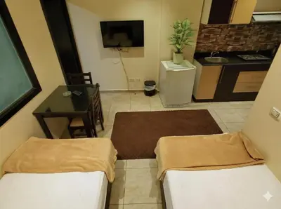 a room with two beds and a table and a kitchen at Poolside Chalet Ground Floor Aqua Park - BY MAMO Property in Hurghada
