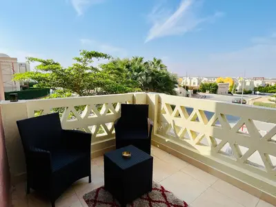 a balcony with two chairs and a white fence at Casa Seherezade in Hurghada