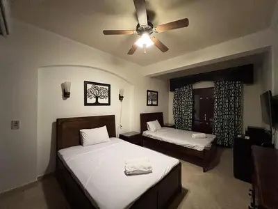 a bedroom with two beds and a ceiling fan at Waterfront Sabina I 4Bdr Retreat - Heated Pool in Hurghada