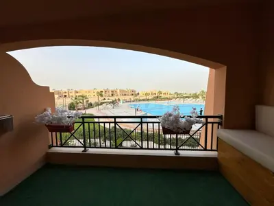 a room with a balcony with a view of a pool at The View Hurghada in Hurghada