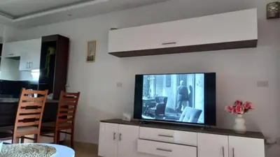 a living room with a flat screen tv on a cabinet at Palma chalet 169 in Hurghada