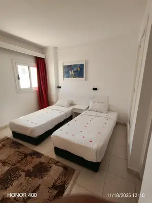 a room with two beds and a window at Elixir Two Bed Rooms in Hurghada