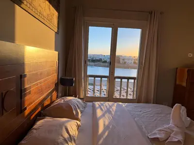 a bedroom with a bed and a large window at The Nest Namaste - El Gouna in Hurghada