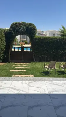 two chairs sitting in the grass in a yard at Sky Star Villa 30 in Hurghada