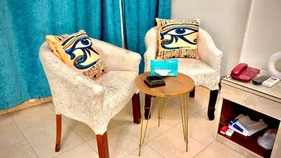 two chairs and a table in a room at Nile Hotel in Aswan