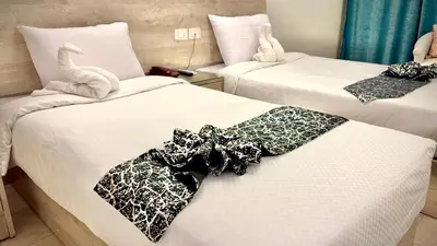 a hotel room with two beds with towels on them at Nile Hotel in Aswan