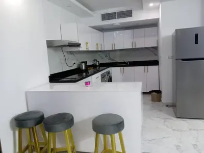 a kitchen with three bar stools and a counter at fanadir resort in Hurghada