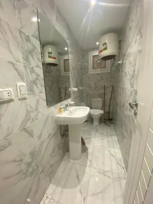 a white bathroom with a sink and a toilet at Fanadir Chalet 3BR in Hurghada