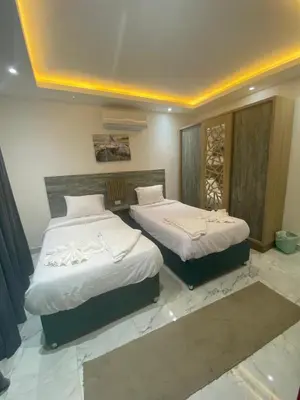a bedroom with two beds with white sheets at Fanadir Chalet 3BR in Hurghada