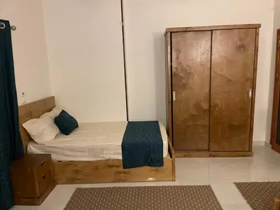a bedroom with a bed and a wooden cabinet at Luxe Nest Luxor Serviced Apartments 201 in Luxor