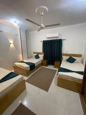 a bedroom with two beds and a ceiling fan at Luxe Nest Luxor Serviced Apartments 201 in Luxor