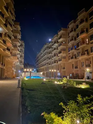 a large apartment building at night with a green lawn at Turtle beach resort in Hurghada