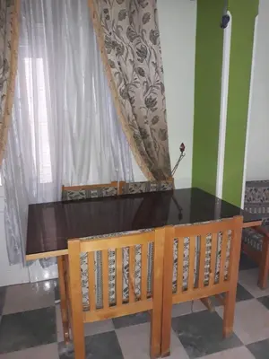 a dining room table with a bench and a window at Obelisk house in Luxor
