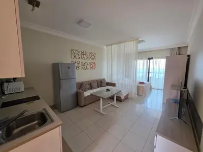 a kitchen and living room with a couch and a refrigerator at New studio in the view in Hurghada