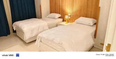 two beds in a hotel room with white sheets at Moon Hills Palace in Hurghada