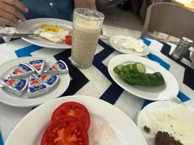 a table with plates of food and a glass of milk at Villa Shanhouri Nile View in Luxor