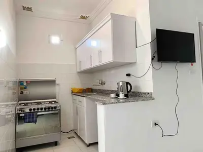 a white kitchen with a stove and a microwave at Villa Shanhouri Nile View in Luxor