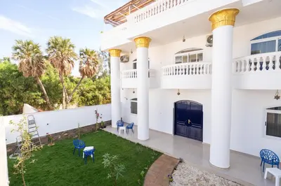 an exterior view of a white house with columns at Home of ISIS in Luxor