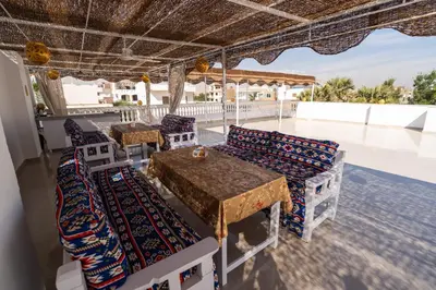 a patio with a table and chairs on a roof at Home of ISIS in Luxor