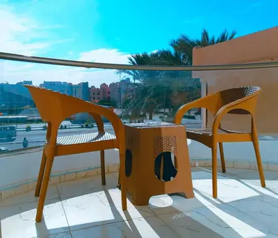 two chairs and a table on a balcony at stylish cozy one bedroom apartment in Hurghada