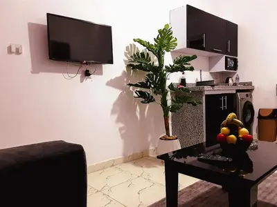 a living room with a table and a tv at stylish cozy one bedroom apartment in Hurghada