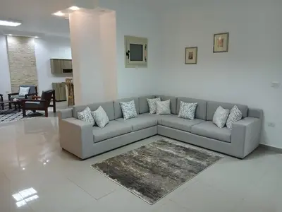 a living room with a gray couch and a rug at Sea View 2 Bedroom Apartment in El-Hadaba in Hurghada