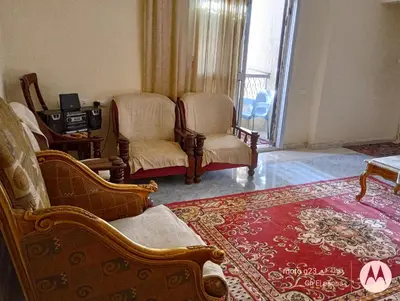 a living room with two chairs and a rug at بيت فرح in Nag` el-Fuqâhi