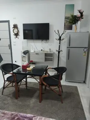 a kitchen with a table and two chairs and a refrigerator at Hurghada neighborhoods in Hurghada