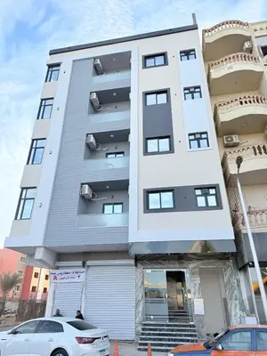 a white building with a car parked in front of it at VERO Residence in Banī Ghālib