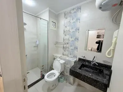 a bathroom with a toilet and a sink and a shower at VERO Residence in Banī Ghālib