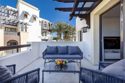 a patio with a blue couch and a bowl of fruit on a table at Dreamy gateway in Ancient Sands in Hurghada