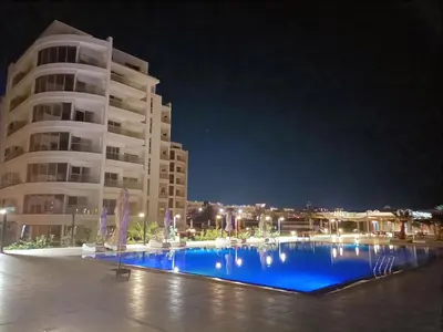 a swimming pool in front of a building at night at Scandic Resort holiday apartment in Hurghada