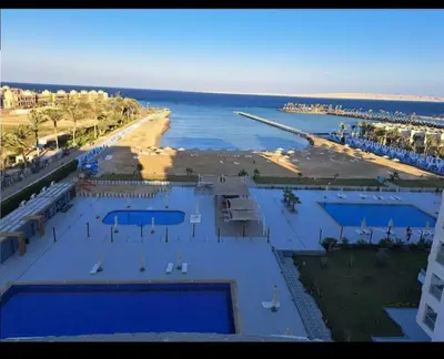 an aerial view of a beach with two swimming pools at Scandic Resort holiday apartment in Hurghada