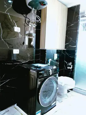 a washing machine in a bathroom with black tiles at VIP villa heated pool & Spa & fully entertained in Hurghada