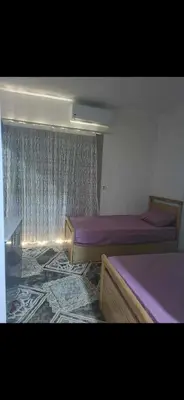 a bedroom with two beds and a window at Al helal in Hurghada