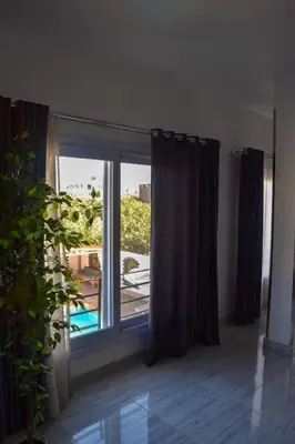 a room with a window with a view of a balcony at Quiet Corner Apartment in Luxor