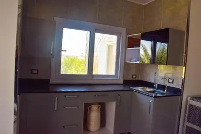 a small kitchen with a sink and a window at Quiet Corner Apartment in Luxor