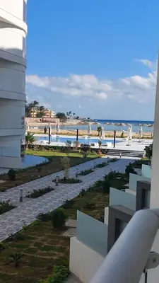 a view of the beach from the balcony of a building at Amazing studio in Scandic resort in Hurghada