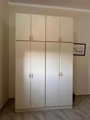 a white closet with white cabinets in a room at Abdalla's House in Al Aqālitah